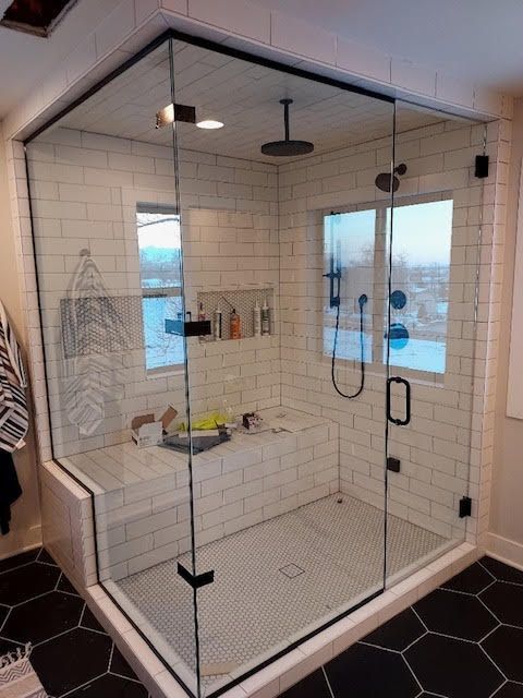 A bathroom with a walk in shower and a window.