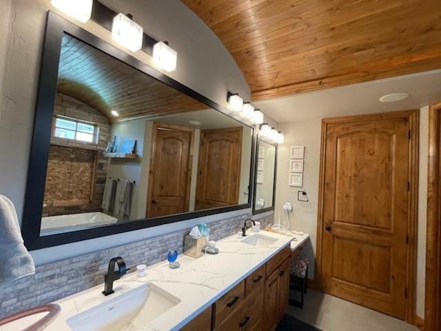 A bathroom with two sinks and a large mirror.