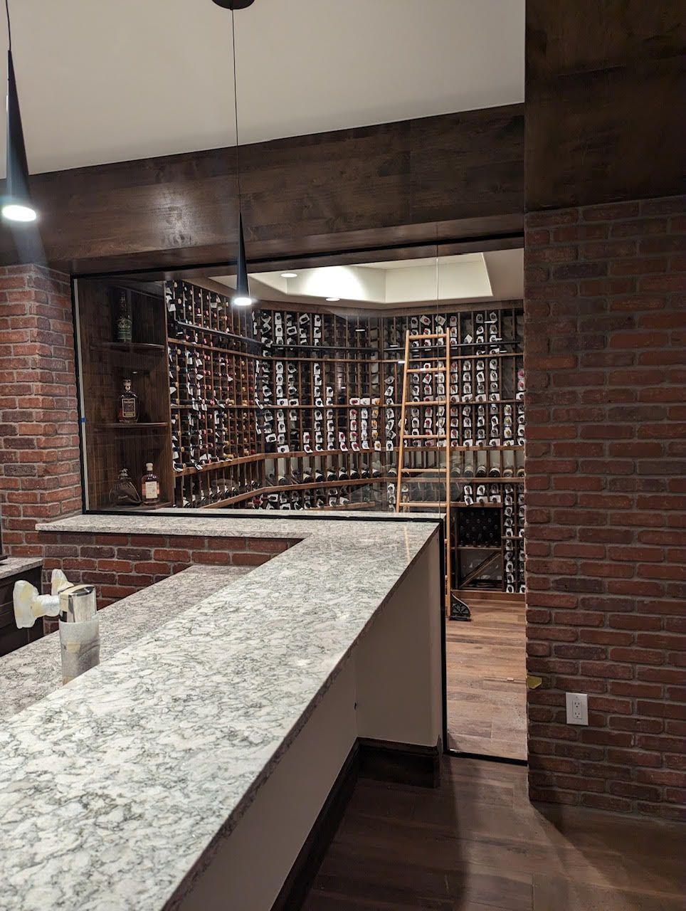 A wine cellar with a brick wall and a granite counter top.