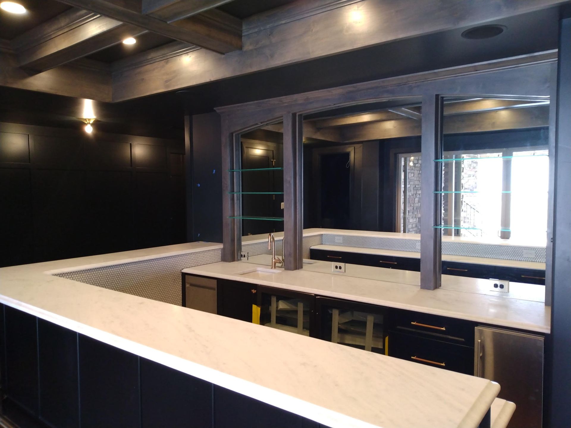 A kitchen with a long counter and a sink.