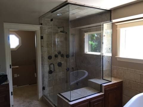 A bathroom with a walk in shower and a tub.