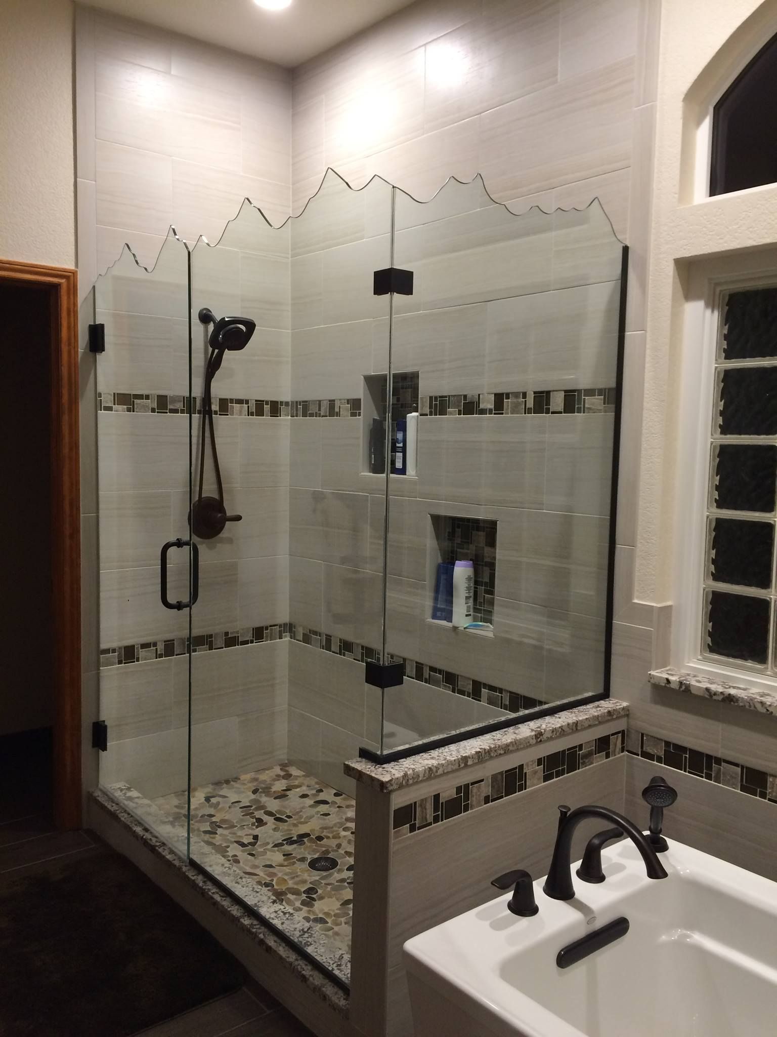 A bathroom with a tub and a shower with a glass door.