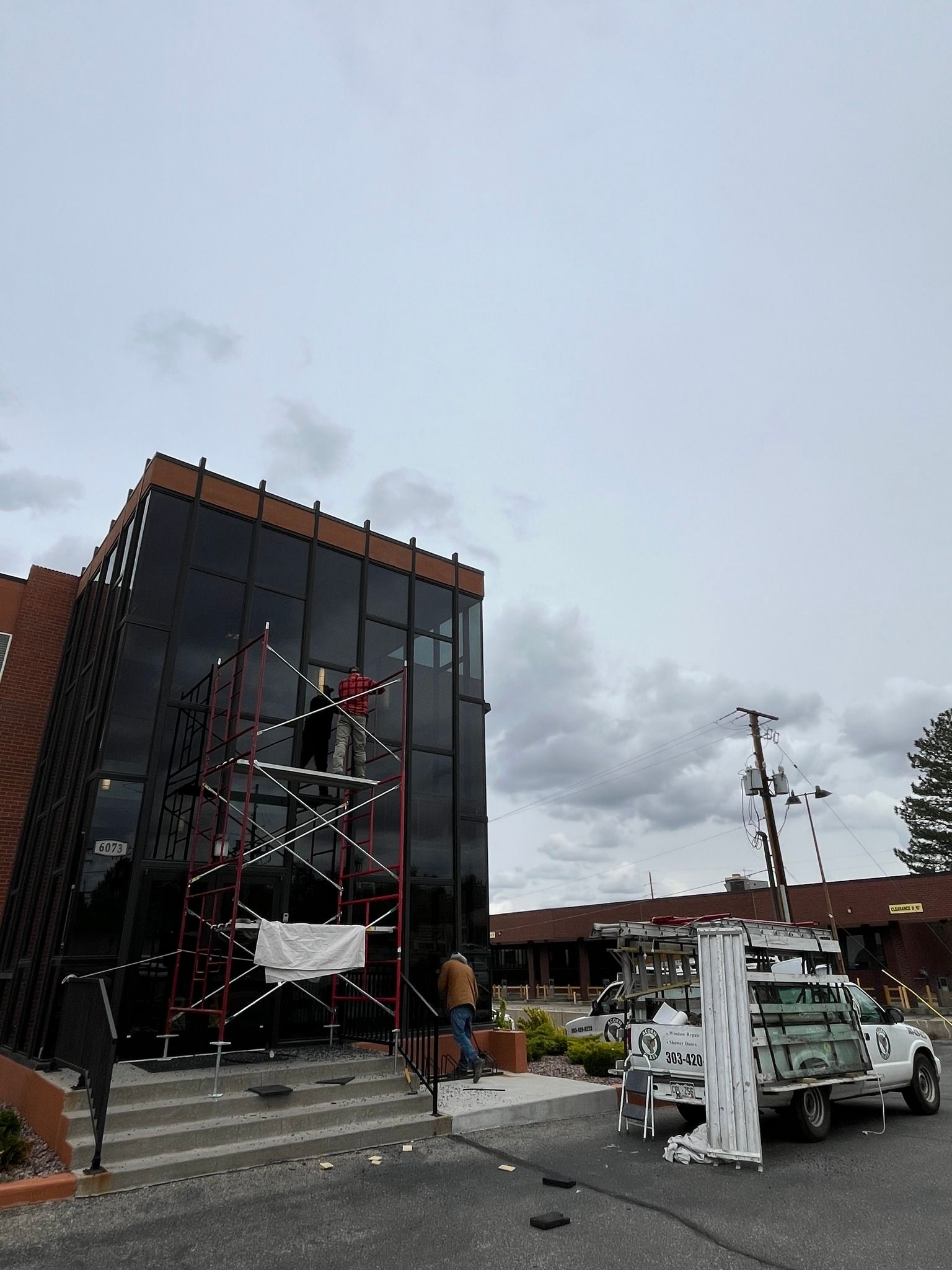 A white truck is parked in front of a large building