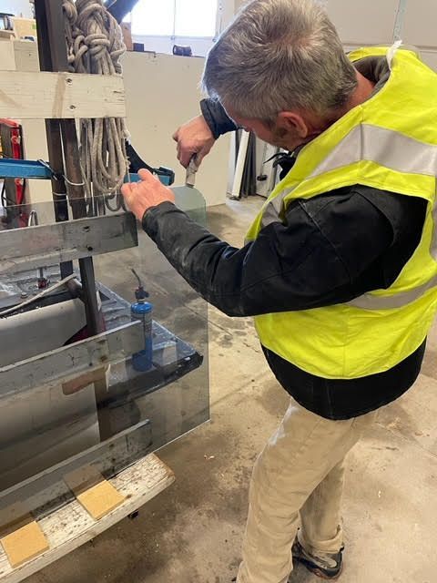 A man in a yellow vest is working on a machine