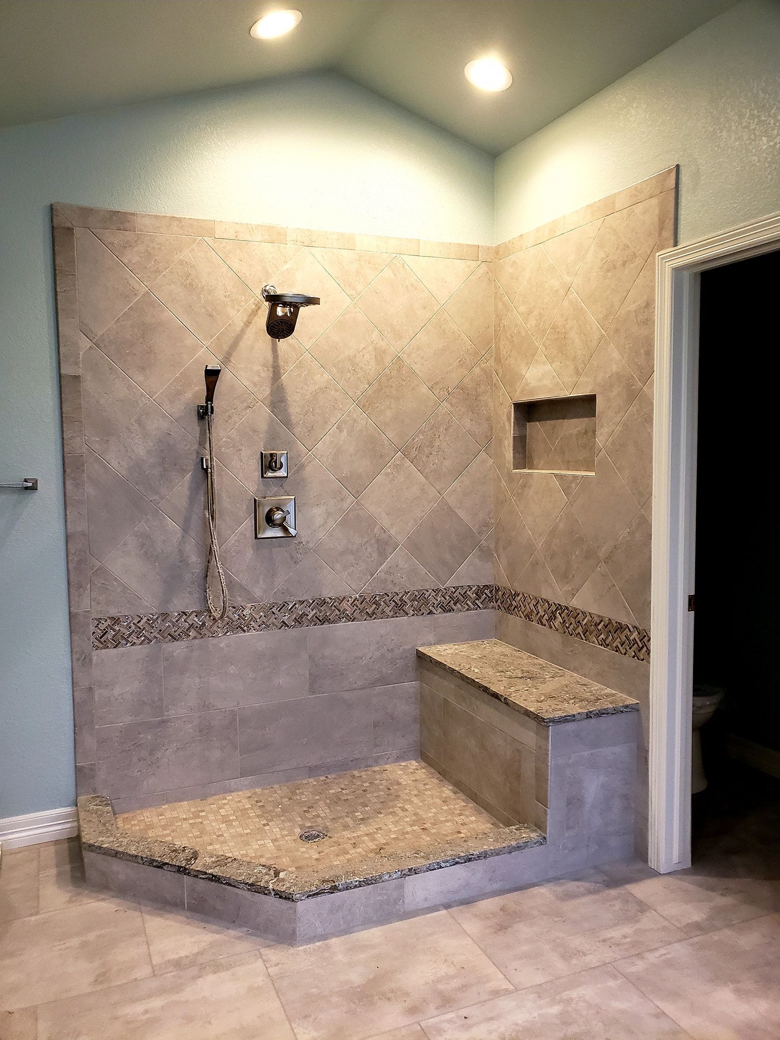 A bathroom with a walk in shower and a toilet.