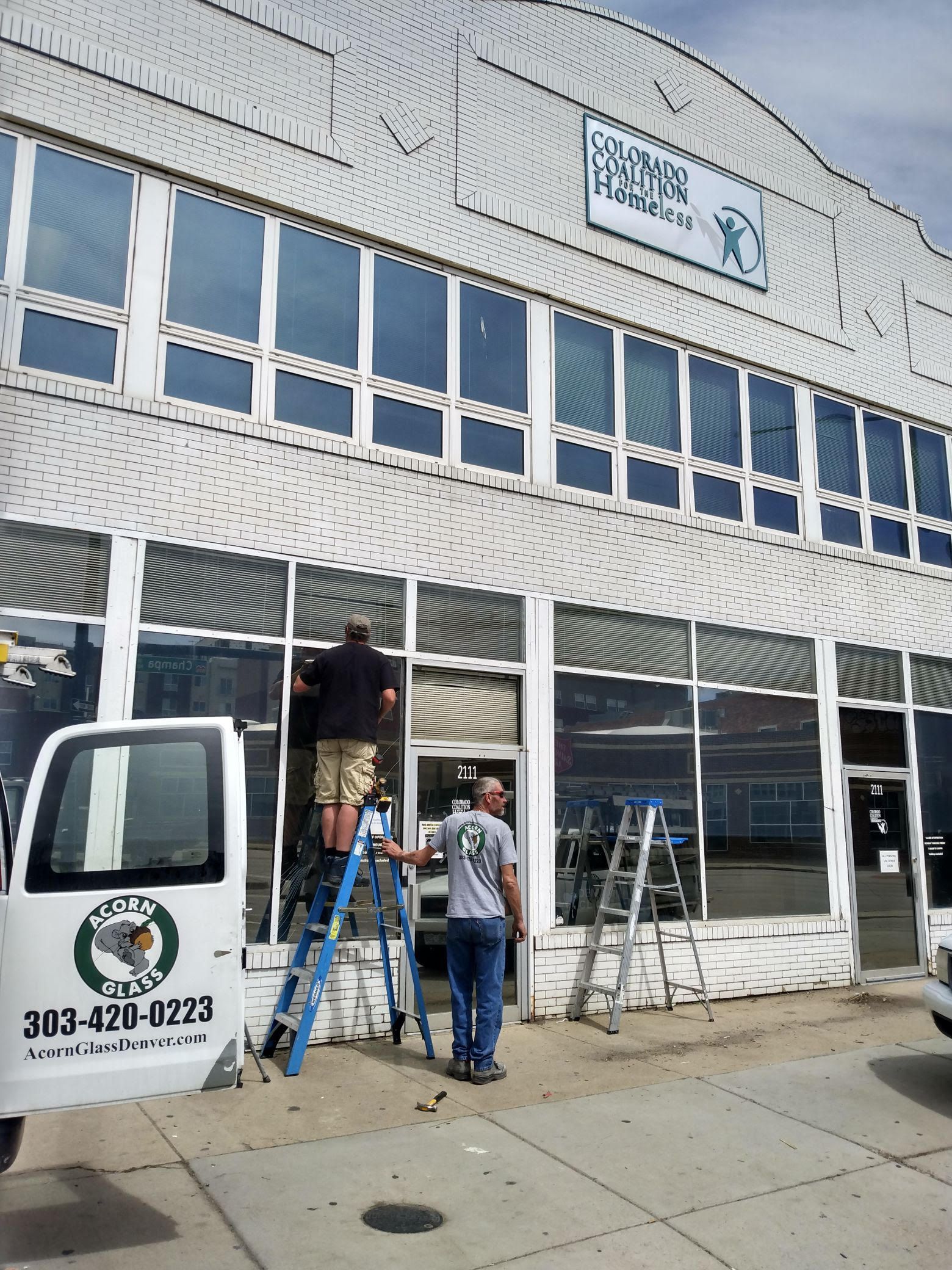 A white truck is parked in front of a large building
