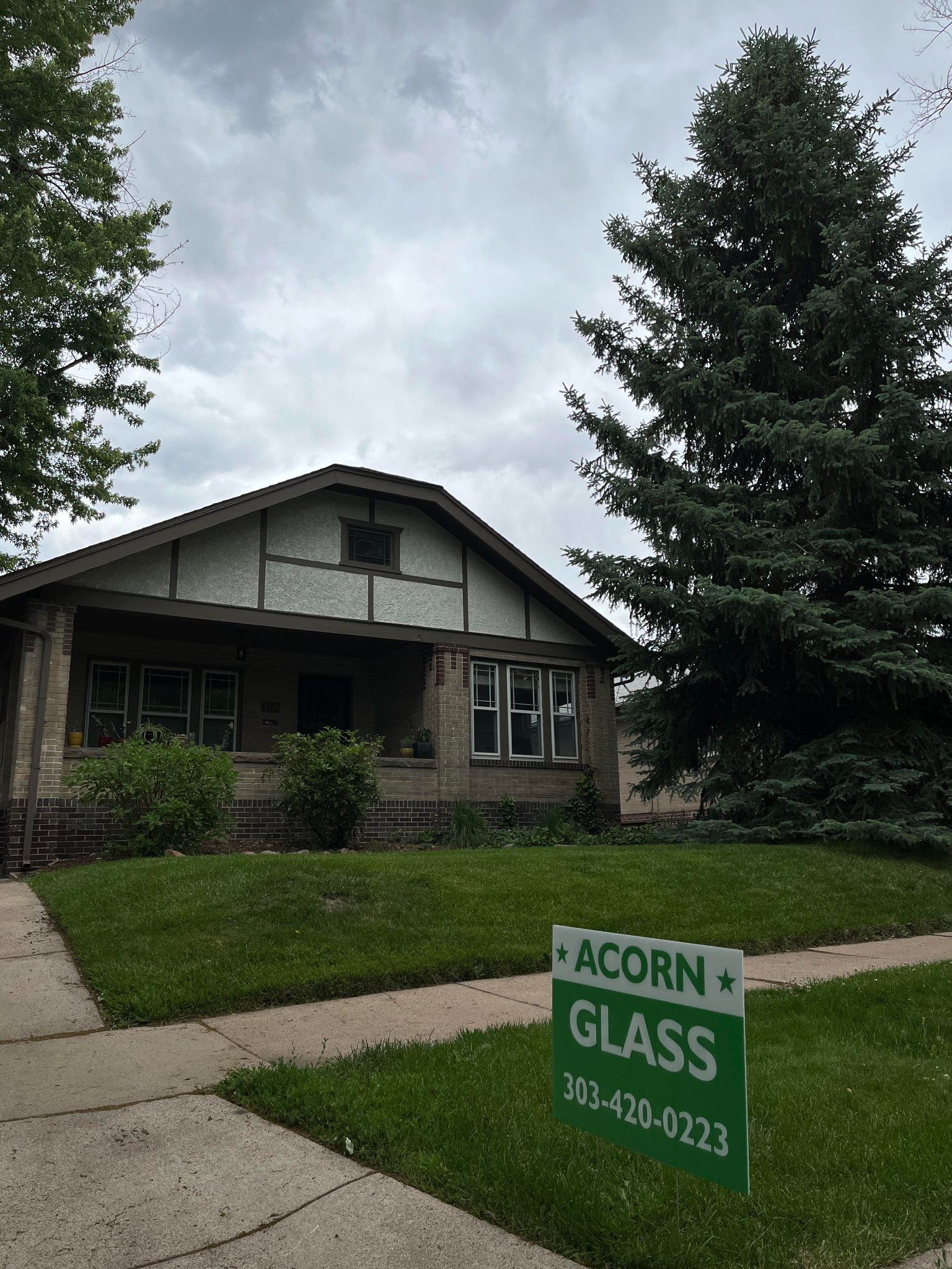 A house with a sign in front of it that says acorn glass.
