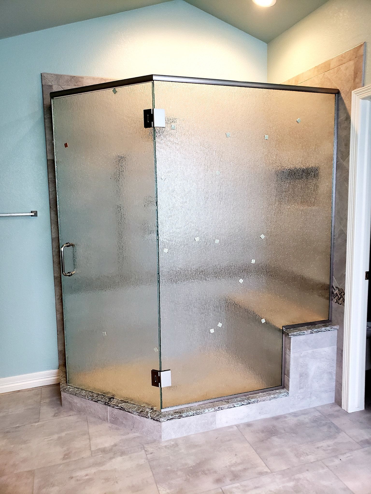 A bathroom with a shower stall with a sliding glass door