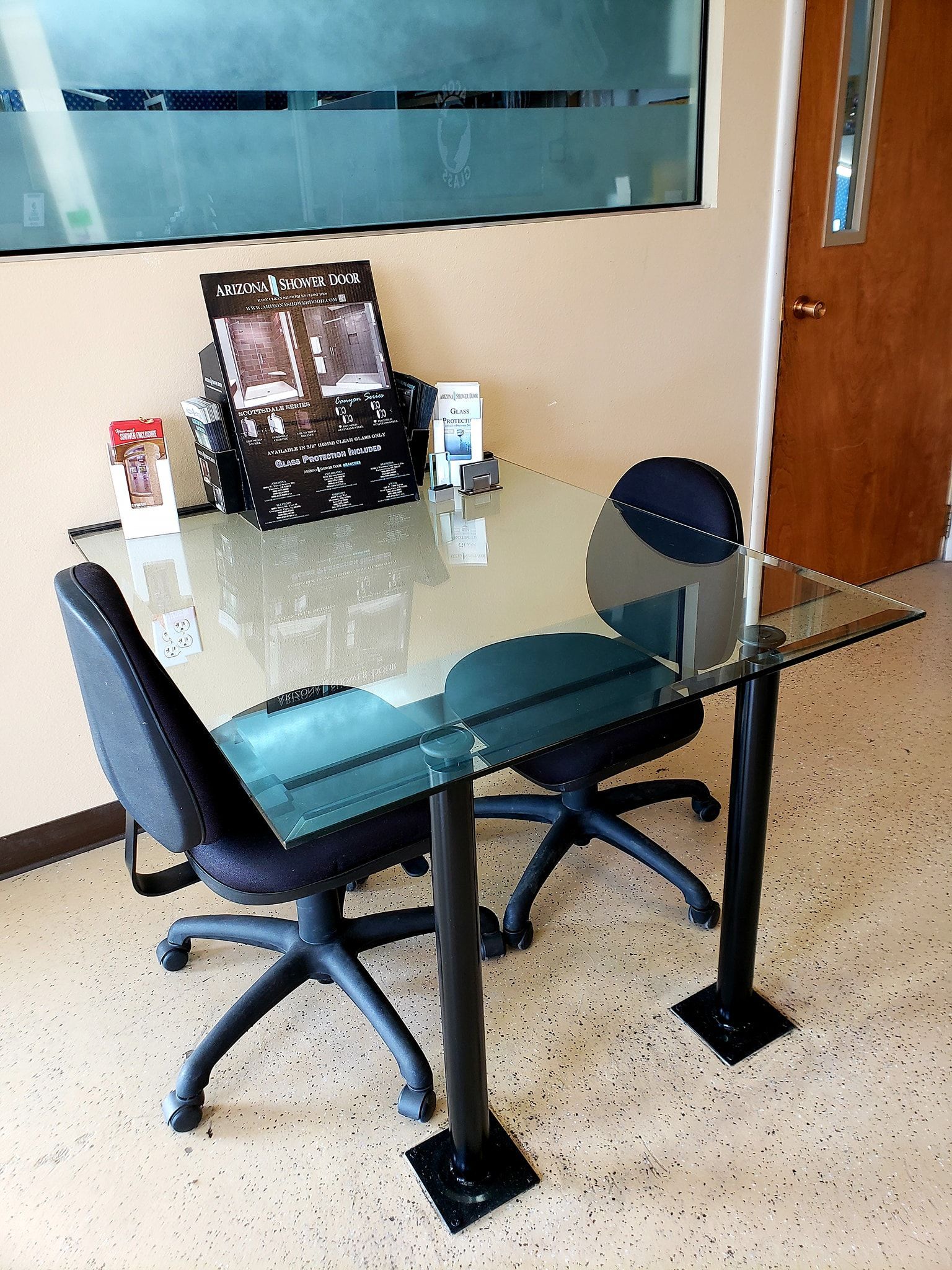 A glass table with two chairs in a room
