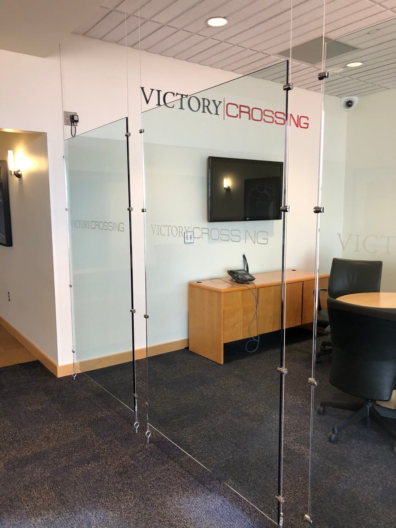 A room with a glass wall and a sign that says victory crossing