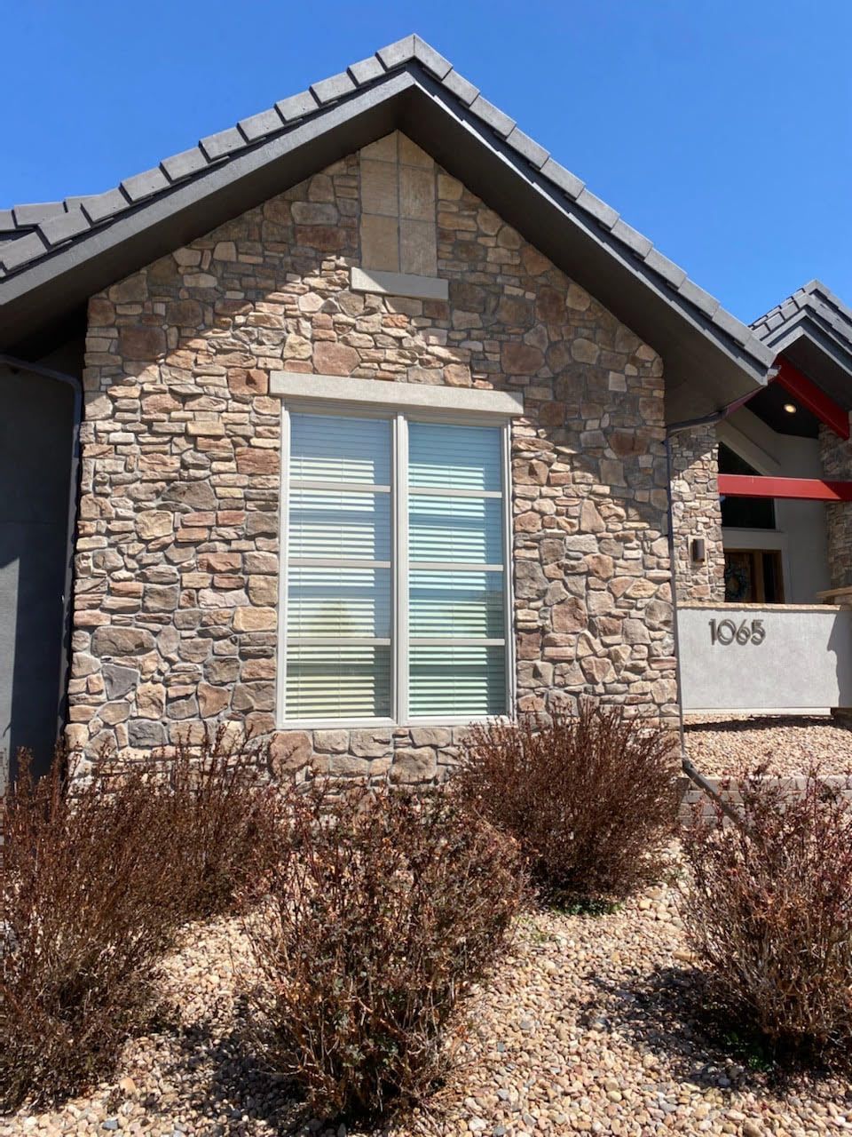 A house with a stone facade and a large window
