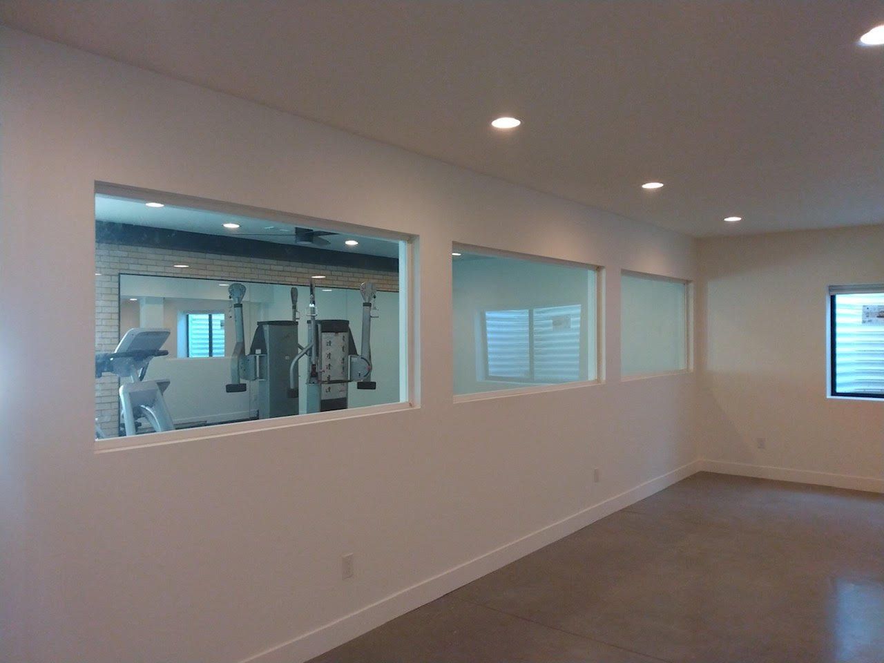 A room with a lot of windows and a gym in the background