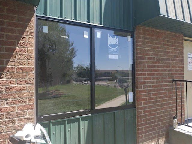 A brick building with a green roof and a window