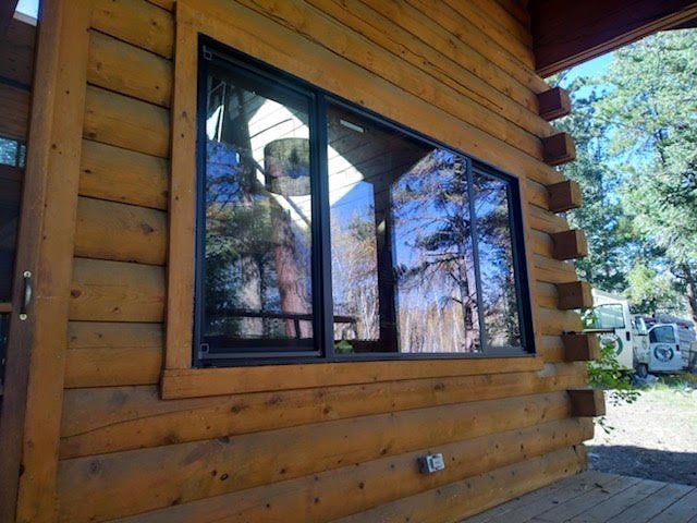 A large window on the side of a log cabin