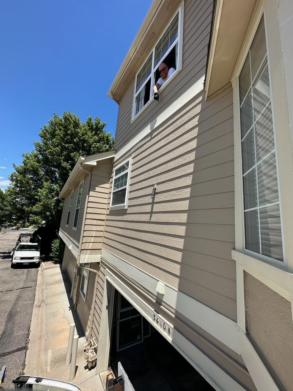 A man is looking out of a window on the side of a house.