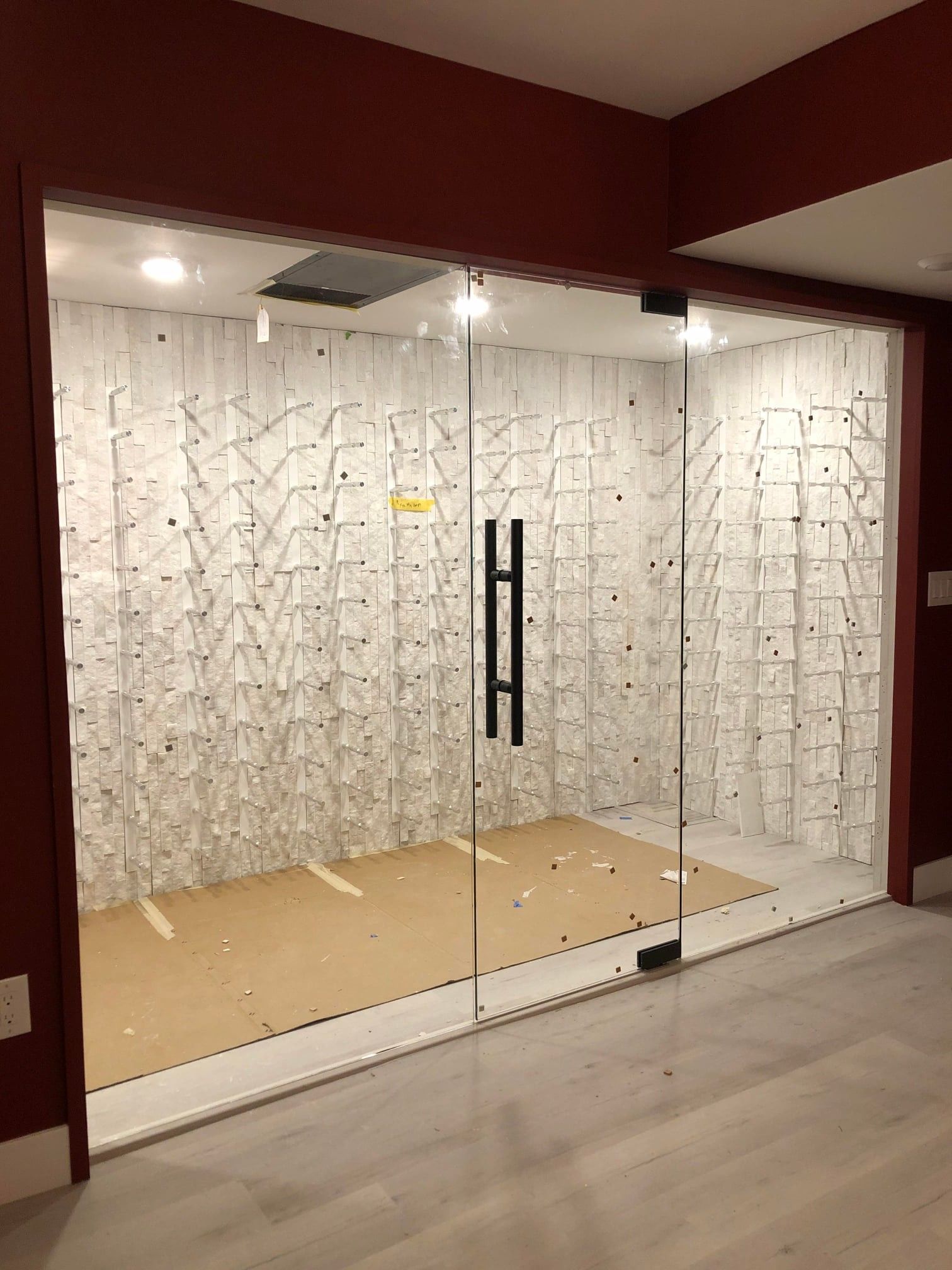 A room with a lot of glass doors and a brick wall.