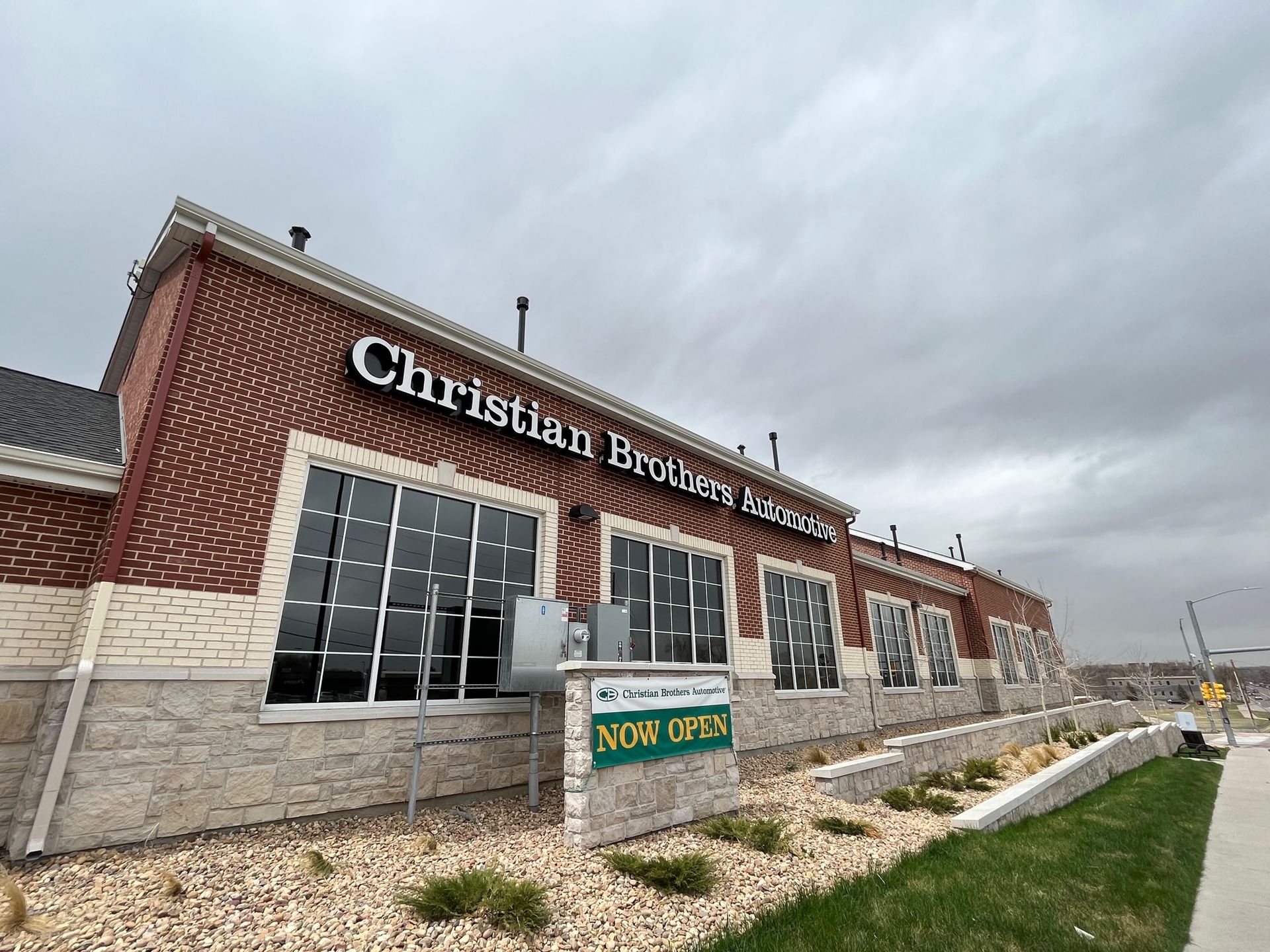 A large brick building with a sign that says `` now open '' on it.