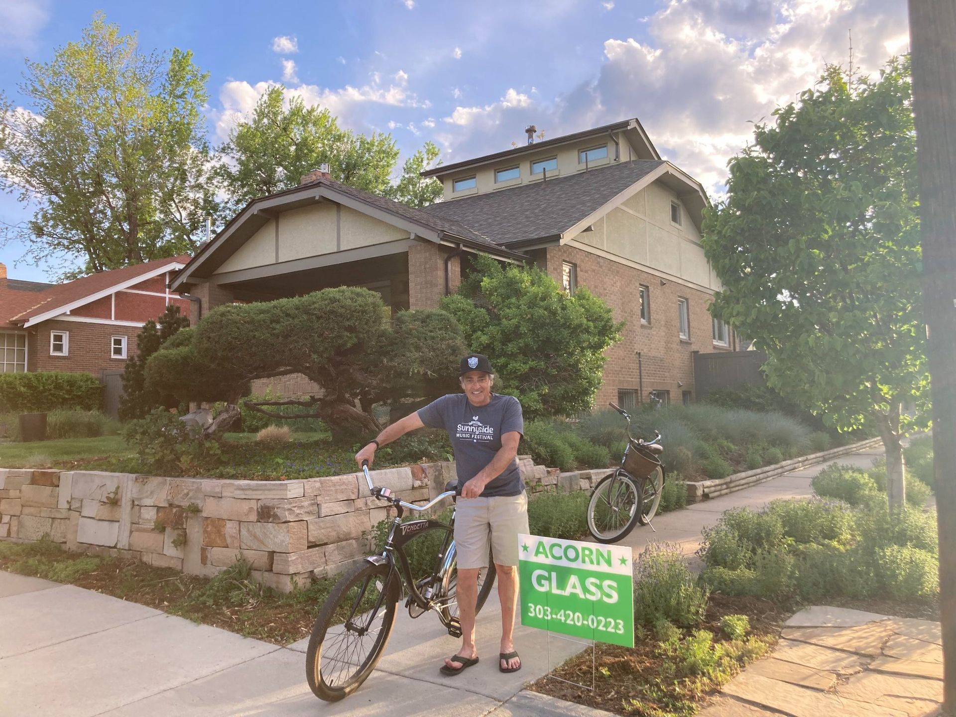 A man is standing next to a bicycle holding a sign that says glass.