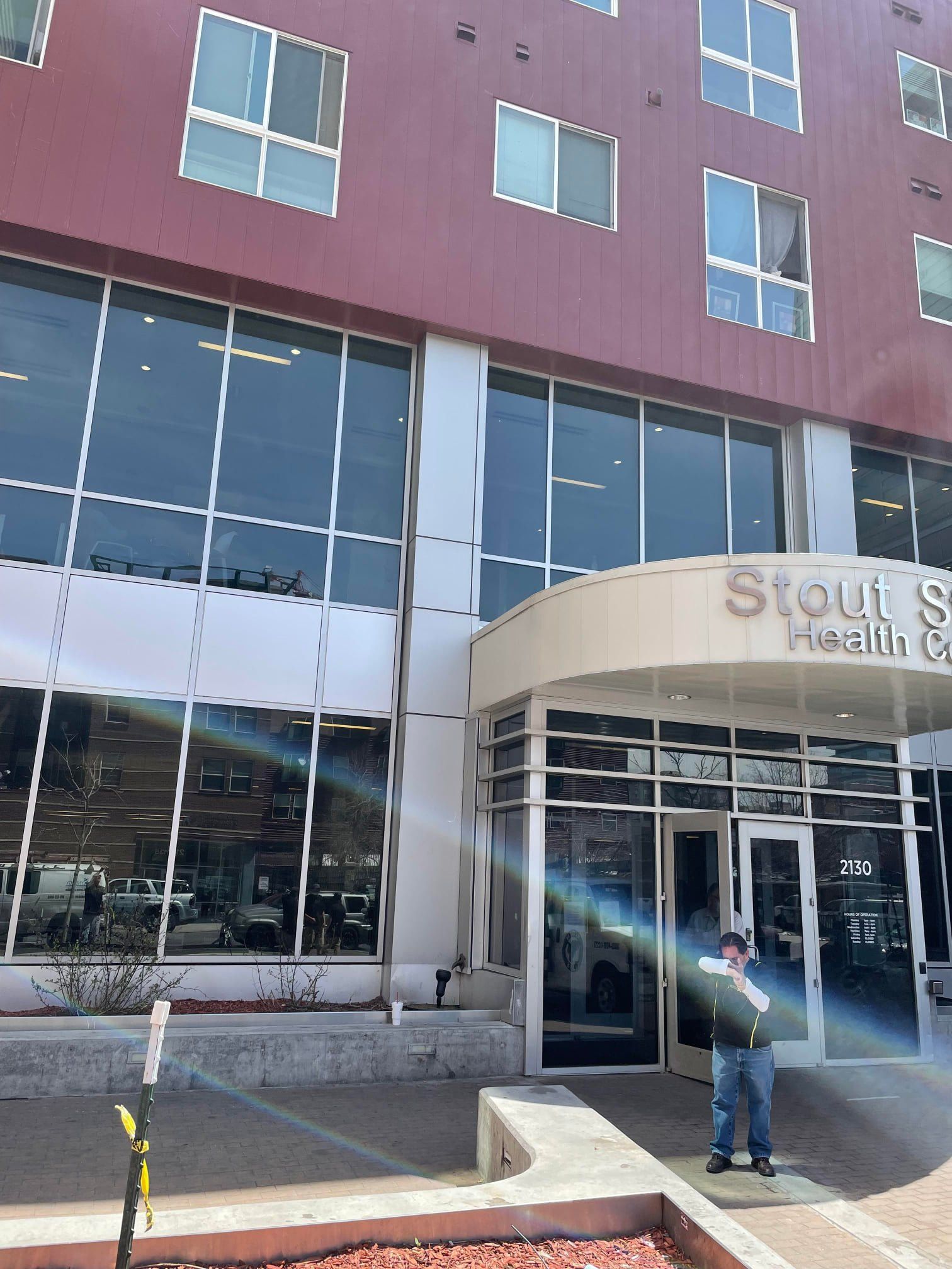 A man stands in front of a building that says stout 's health care