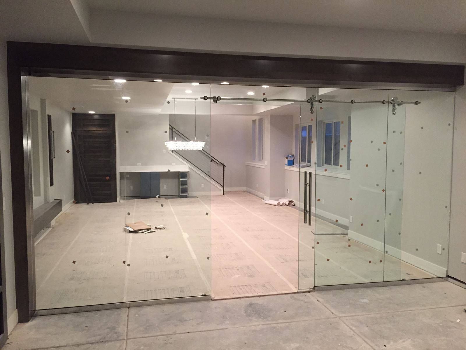 An empty room with sliding glass doors and a staircase.