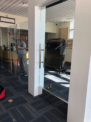 A man is cleaning a glass door in a gym.