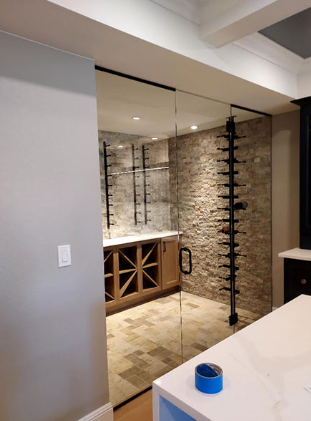 A wine cellar with a glass door and a blue tape on the counter.