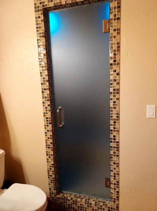 A bathroom with a toilet and a glass shower door.