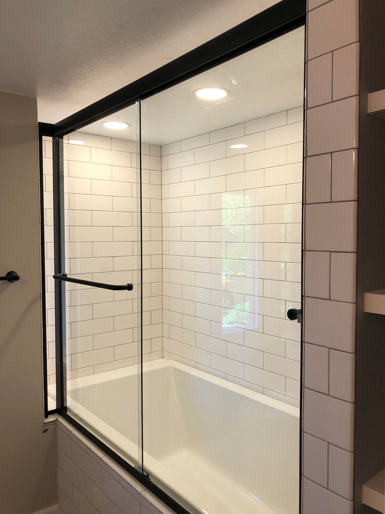 A bathroom with a bathtub and a sliding glass shower door.