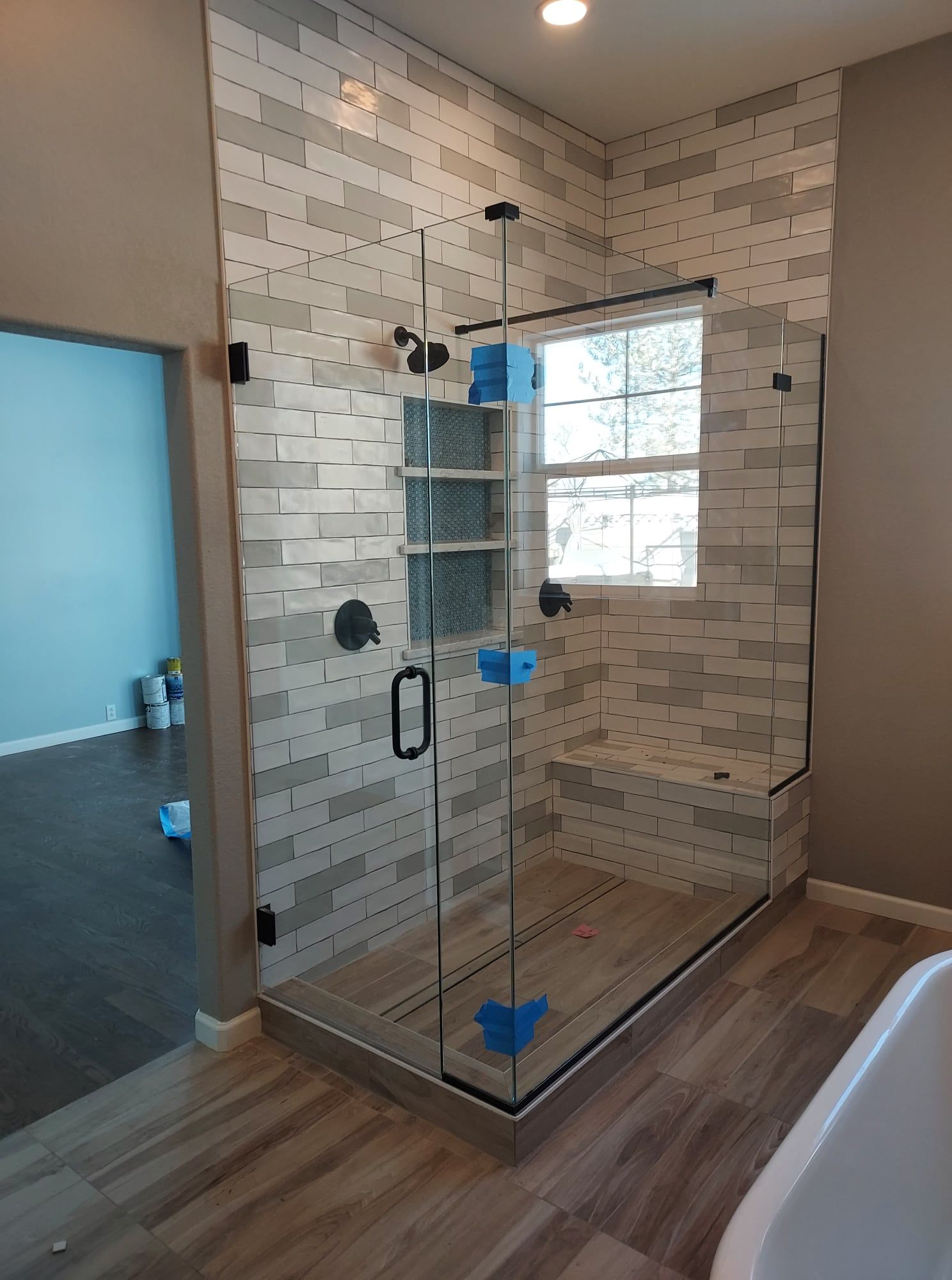 A bathroom with a walk in shower and a bathtub.