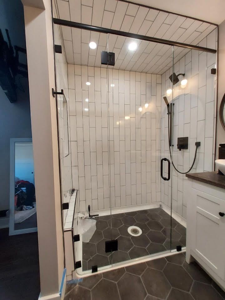 A bathroom with a walk in shower and a sink.
