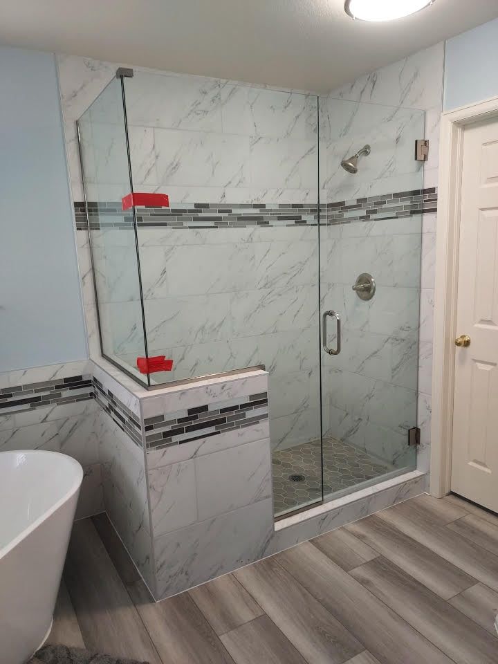 A bathroom with a walk in shower and a bathtub.