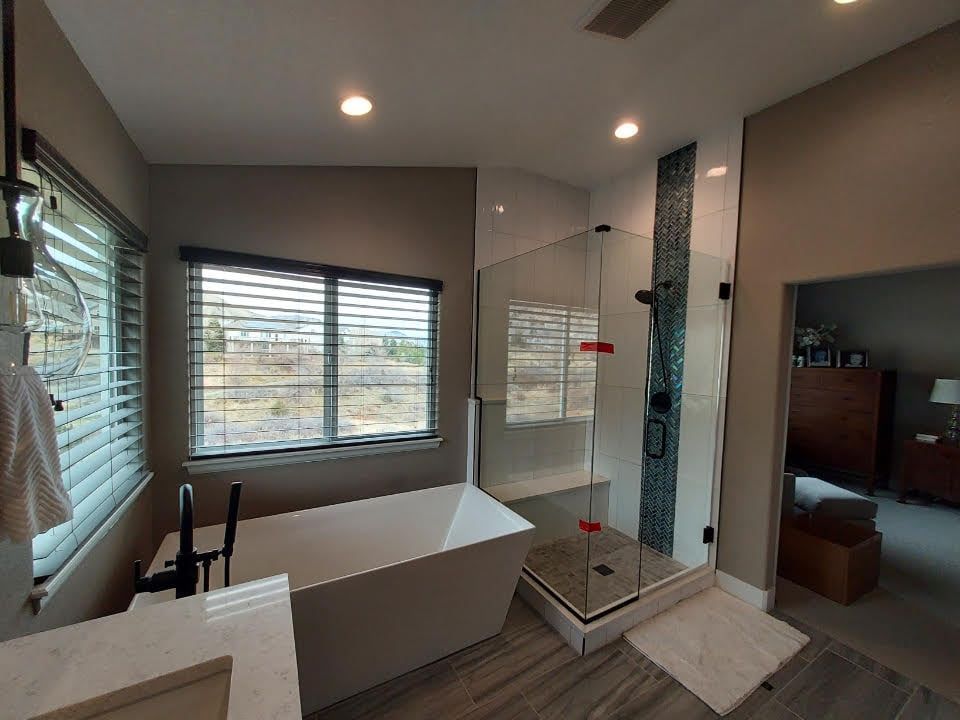 A bathroom with a tub , sink , and shower.