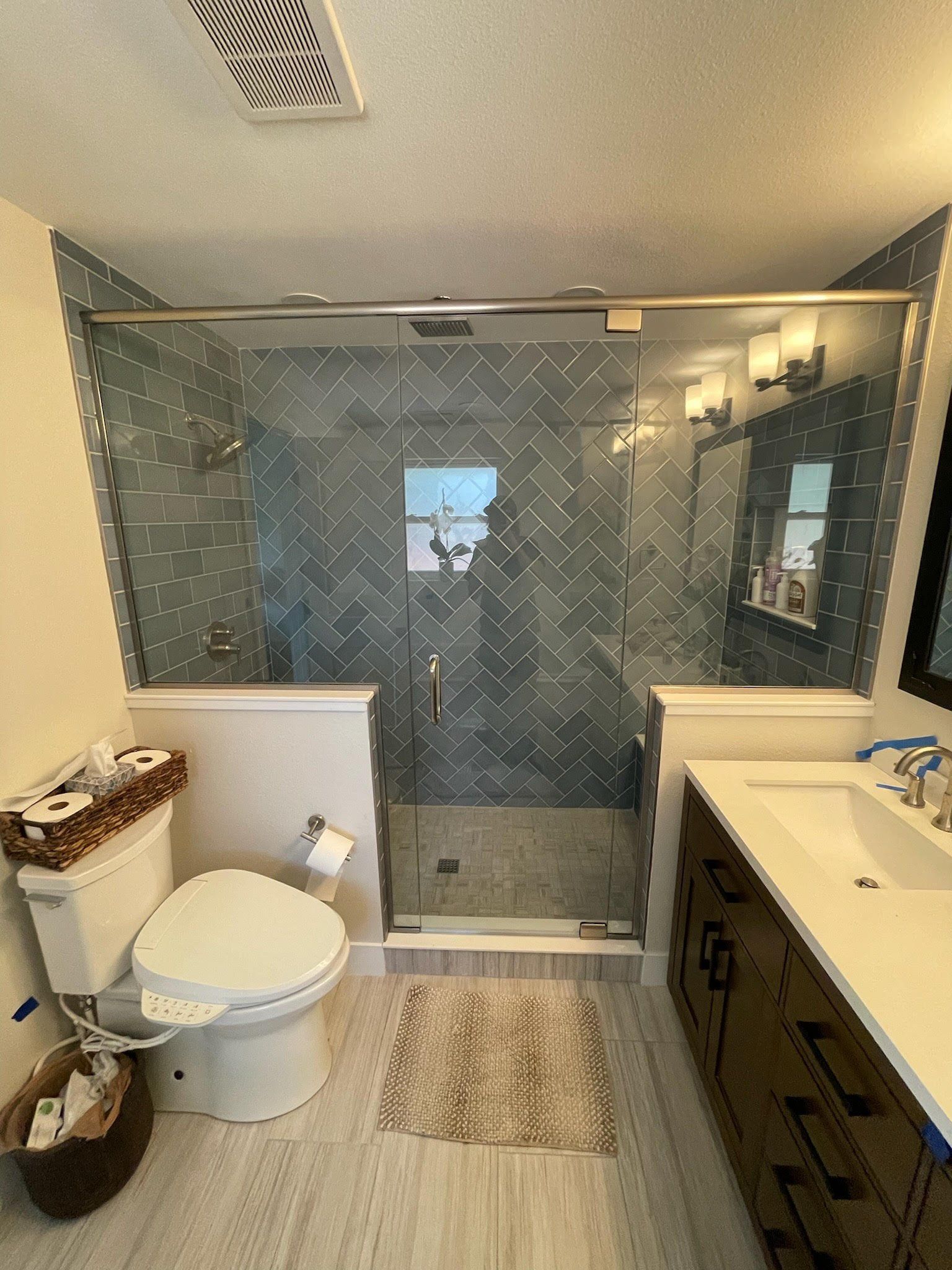 A bathroom with a toilet , sink , and walk in shower.