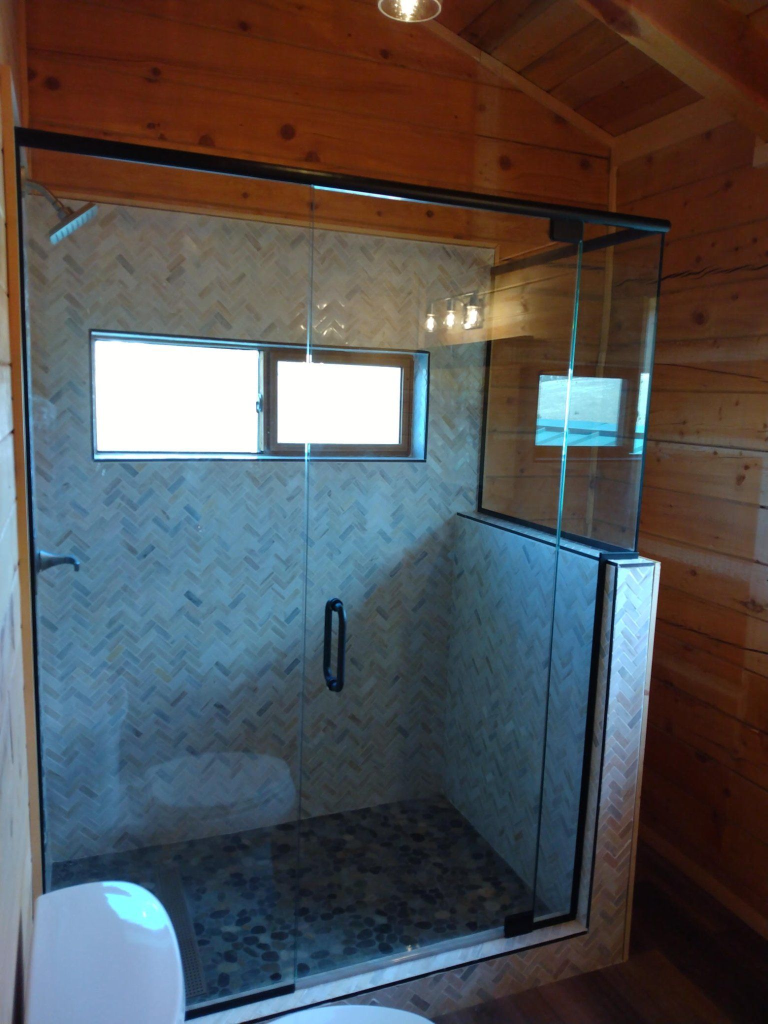 A bathroom with a walk in shower and a toilet.
