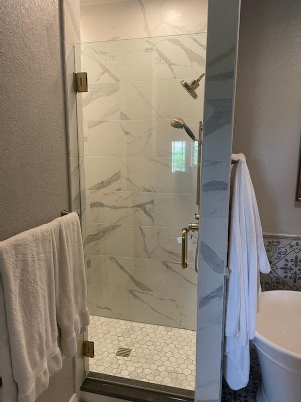 A bathroom with a walk in shower and a bathtub.