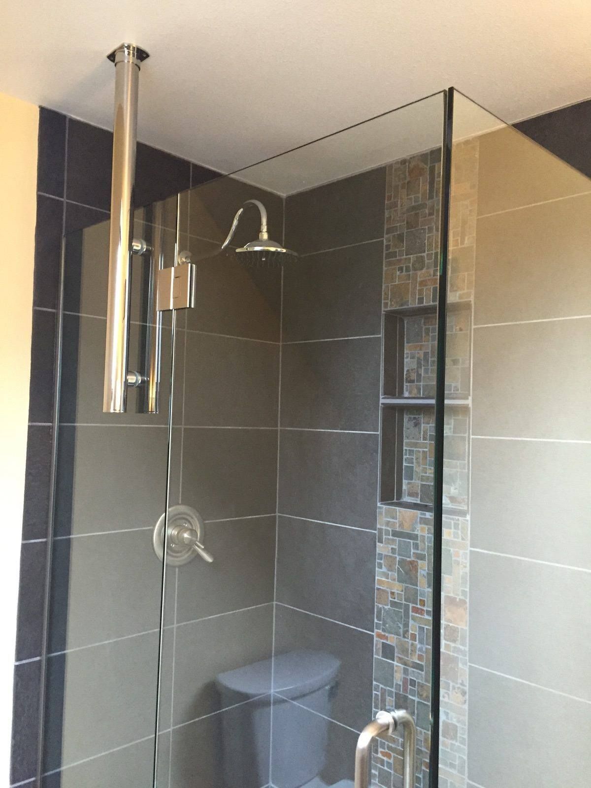 A bathroom with a toilet and a shower with a glass door