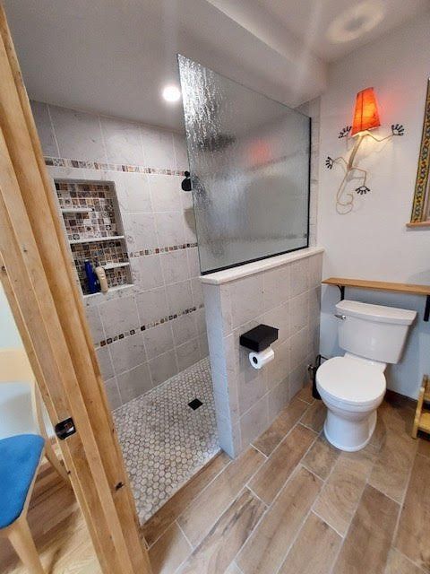 A bathroom with a toilet and a walk in shower.