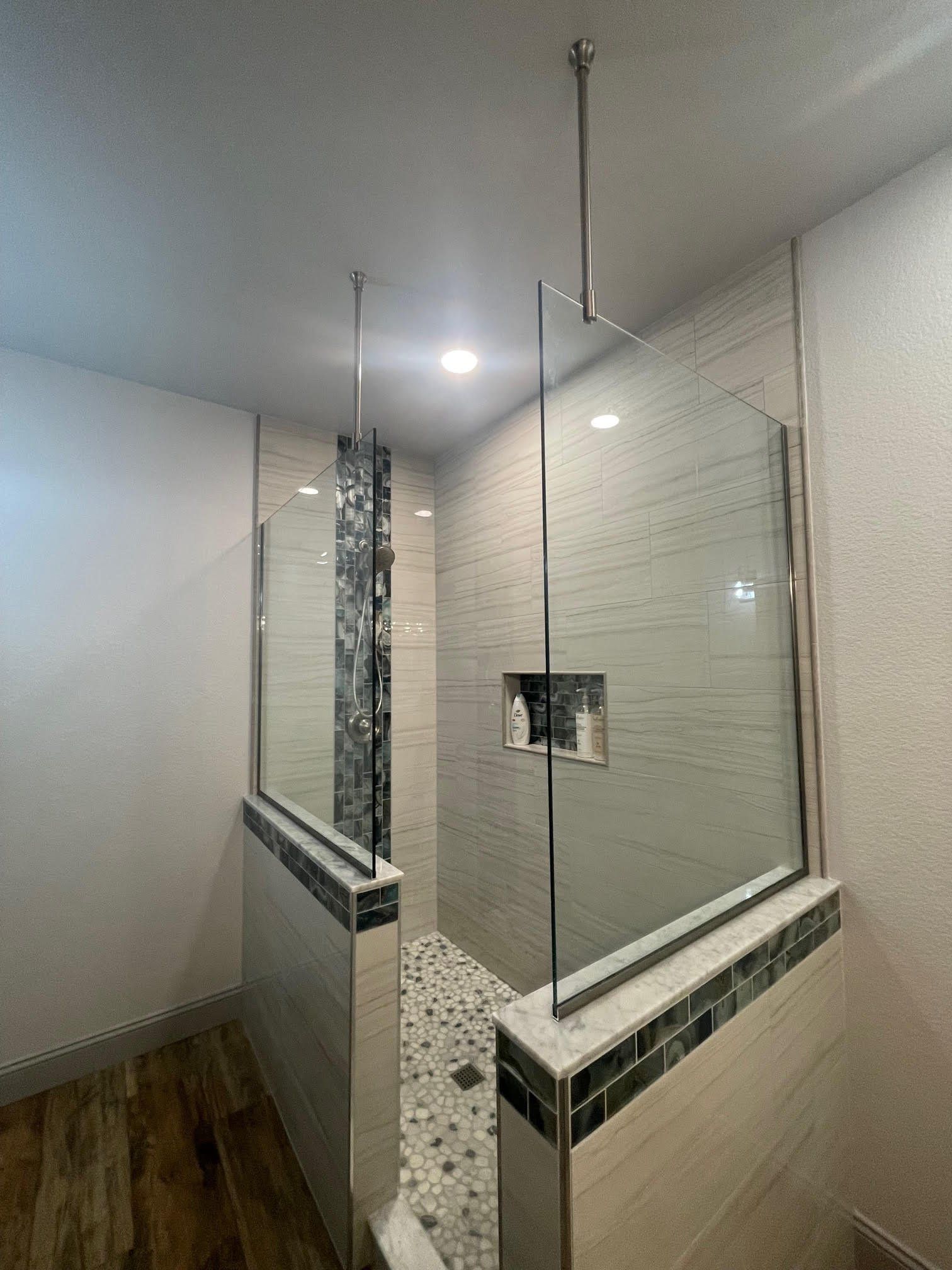 A bathroom with a walk in shower and a glass door.