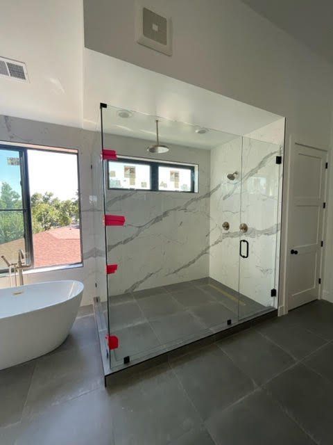 A bathroom with a tub and a walk in shower