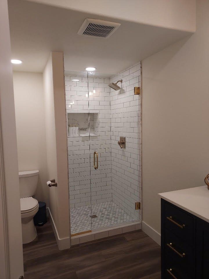 A bathroom with a toilet and a walk in shower.