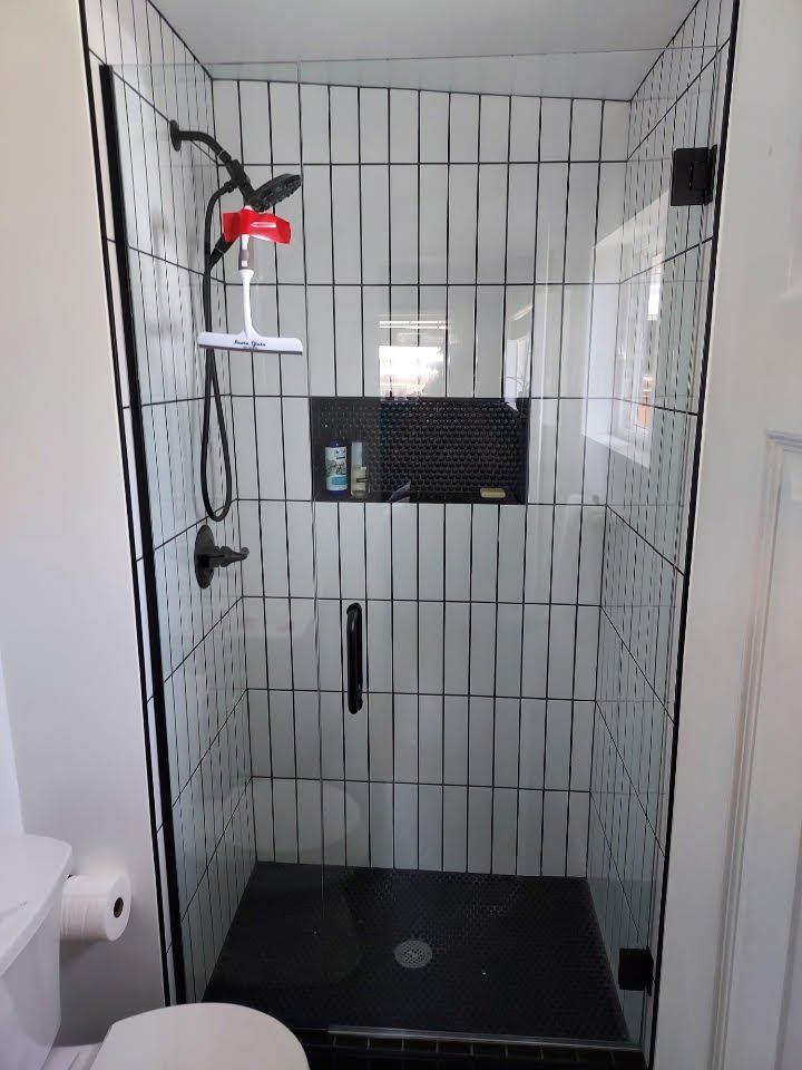 A bathroom with a walk in shower and a toilet.