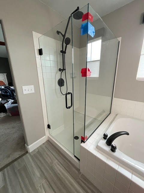 A bathroom with a walk in shower and a bathtub