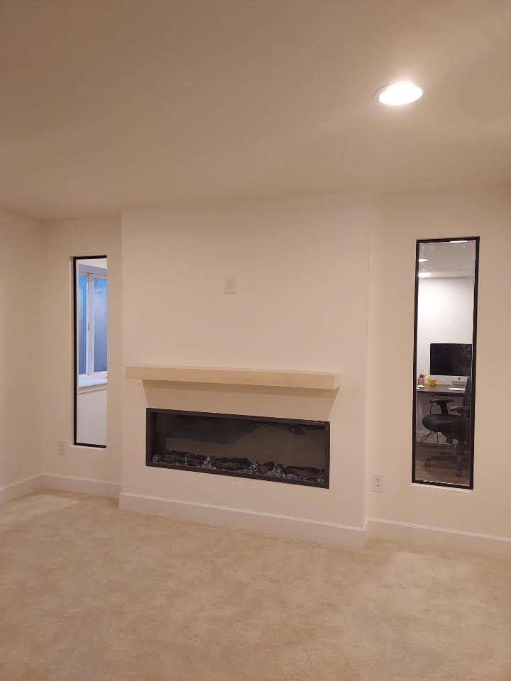 A living room with a fireplace and two mirrors