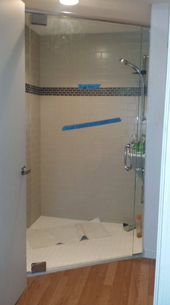A walk in shower with a glass door is being built in a bathroom.