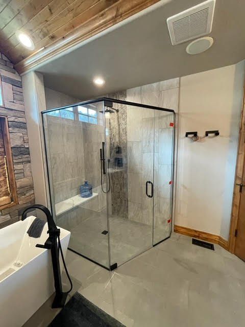 A bathroom with a walk in shower and a bathtub.