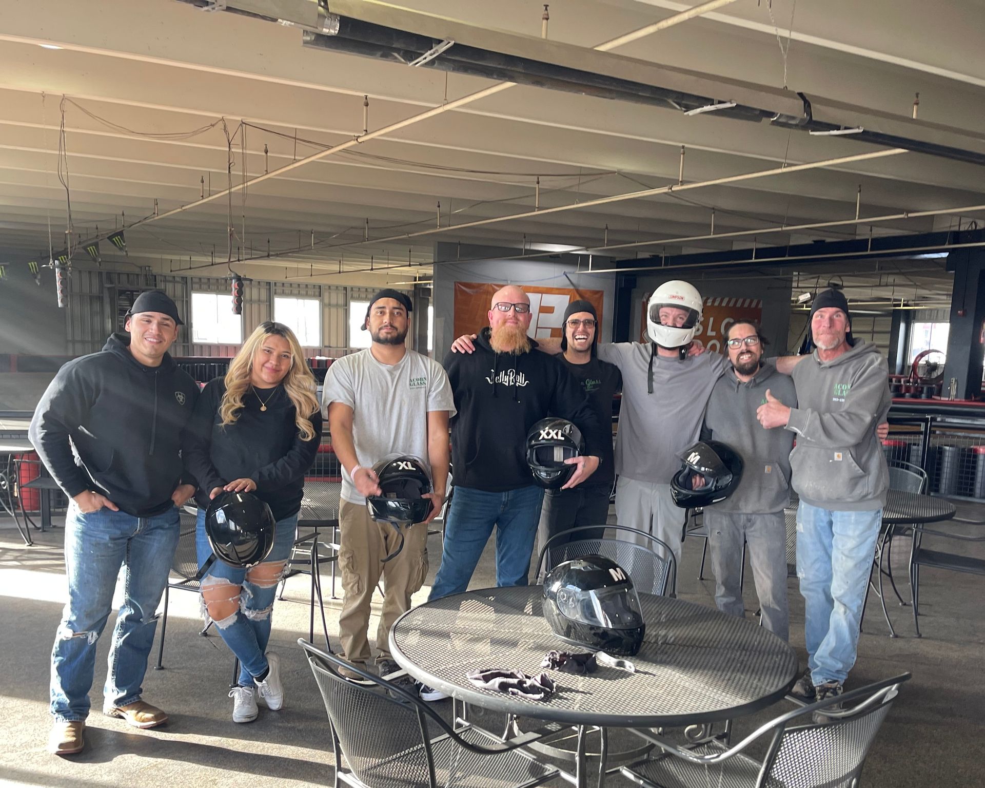 A group of people standing around a table holding helmets.
