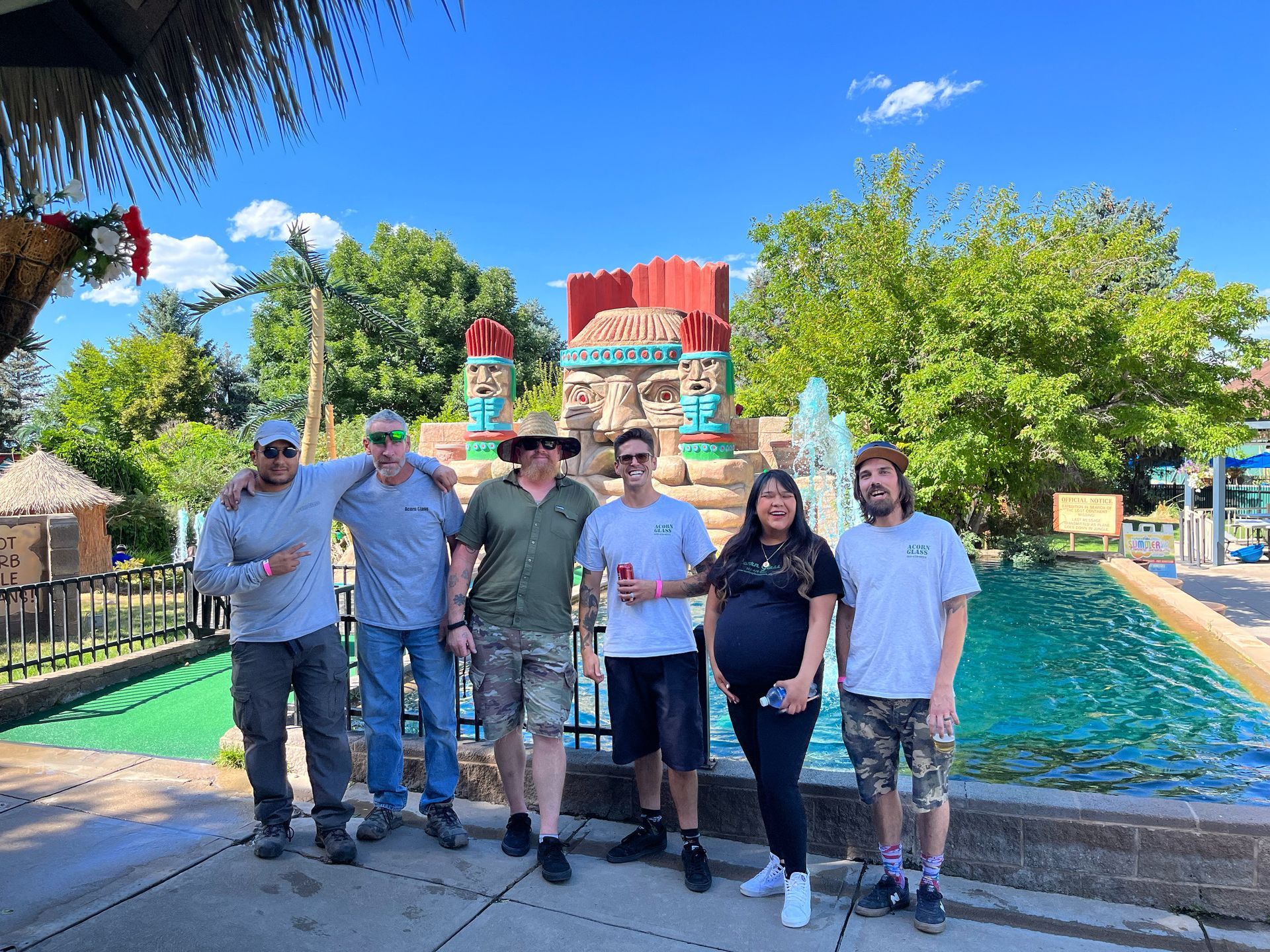 A group of people are posing for a picture in front of a mini golf.