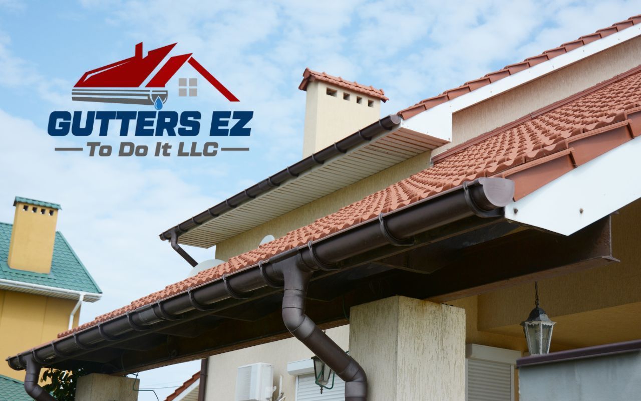 Gutters EZ To Do It LLC logo over a house roof with gutters and downspouts installed