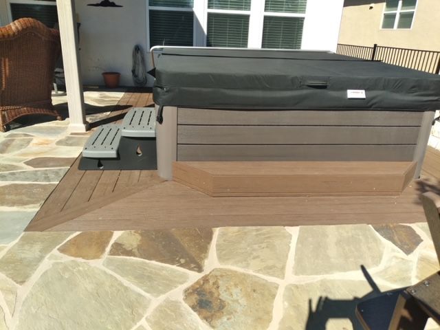 A hot tub is sitting on top of a wooden deck.
