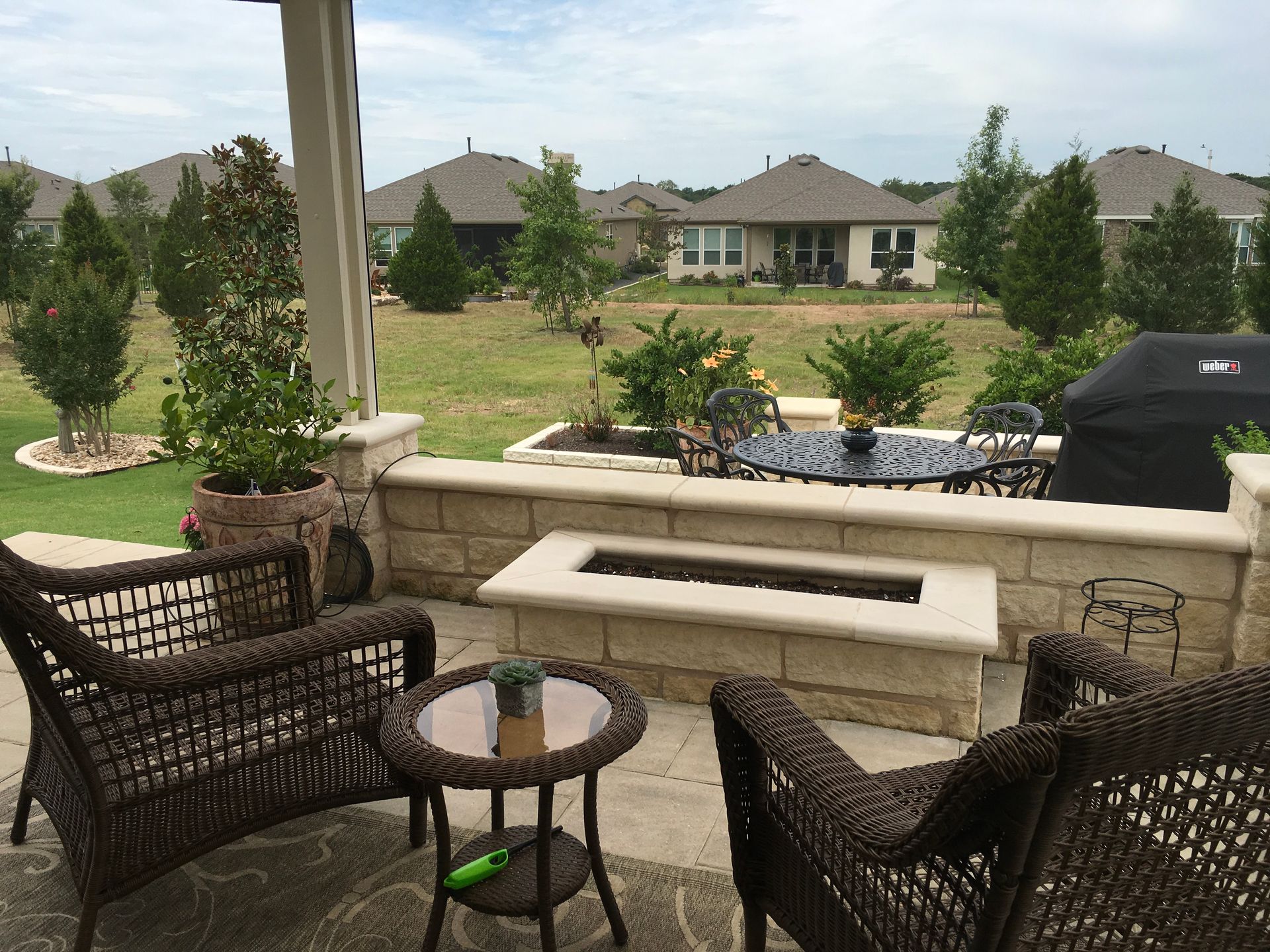 A patio with wicker furniture and a fire pit
